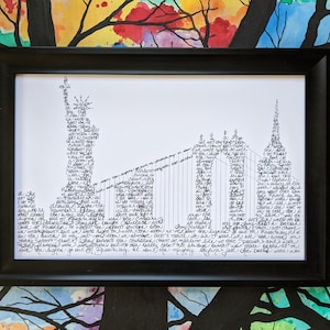 May include: A black and white framed print of a cityscape made of words. The print features the Statue of Liberty, the Brooklyn Bridge, and other iconic New York City landmarks. The words are arranged in a way that creates the shape of the buildings and bridges.