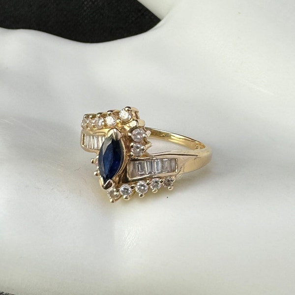 14 Karat Gold ring with deep blue/black Sapphire and fourteen diamonds. Size 7 diamond and oval shaped deep, deep blue sapphire. 12008