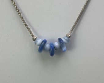 Blaue Glasperlen auf Sterling-Kette: Blaues und weißes Glas, verwirbelte Perlen, zentriert auf einer 40-cm-Sterling-Silber-, Serpentin-Kette. 10194