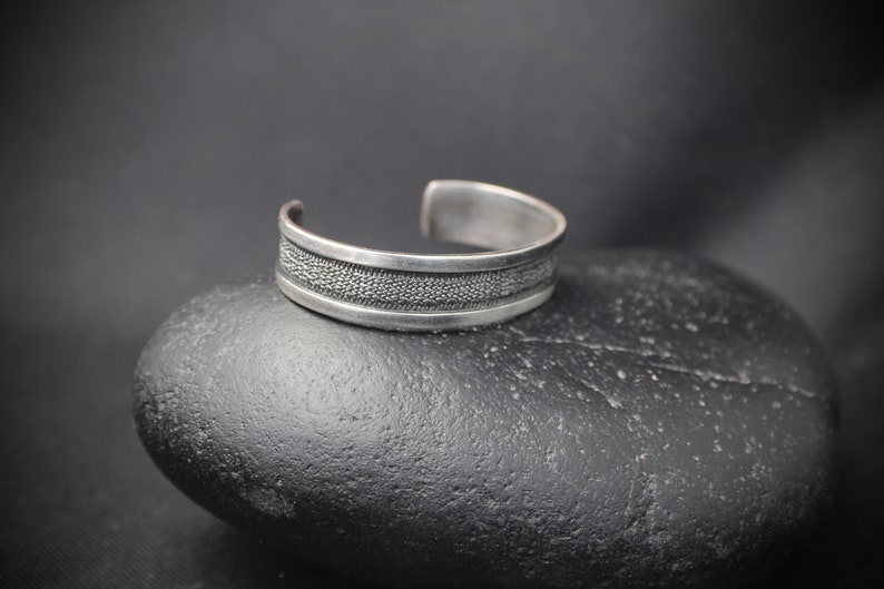 Rustic Silver Styling 3153 Sterling Silver Cuff with a Textured Center on a Black Background With a Smooth Silver Border in Southwestern
