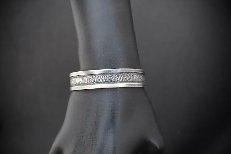 Rustic Silver Styling 3153 Sterling Silver Cuff with a Textured Center on a Black Background With a Smooth Silver Border in Southwestern