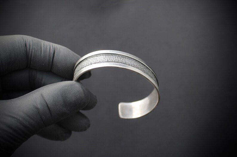 Rustic Silver Styling 3153 Sterling Silver Cuff with a Textured Center on a Black Background With a Smooth Silver Border in Southwestern