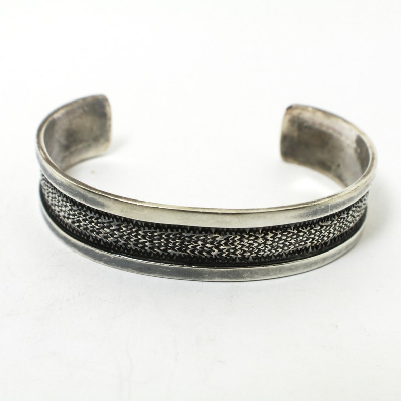 Rustic Silver Styling 3153 Sterling Silver Cuff with a Textured Center on a Black Background With a Smooth Silver Border in Southwestern