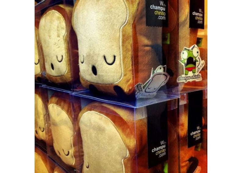 Puede incluir: Juguetes de peluche con forma de rebanadas de pan con caras sonrientes se exhiben en cajas de pl&aacute;stico transparente. El pan tiene un centro de color beige claro y una corteza marr&oacute;n oscuro. El texto "W. champu chinito .com" es visible.