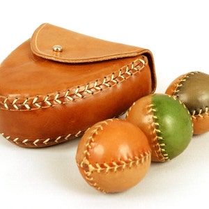 3 pelotas de cuero bicolor con estuche de cuero.