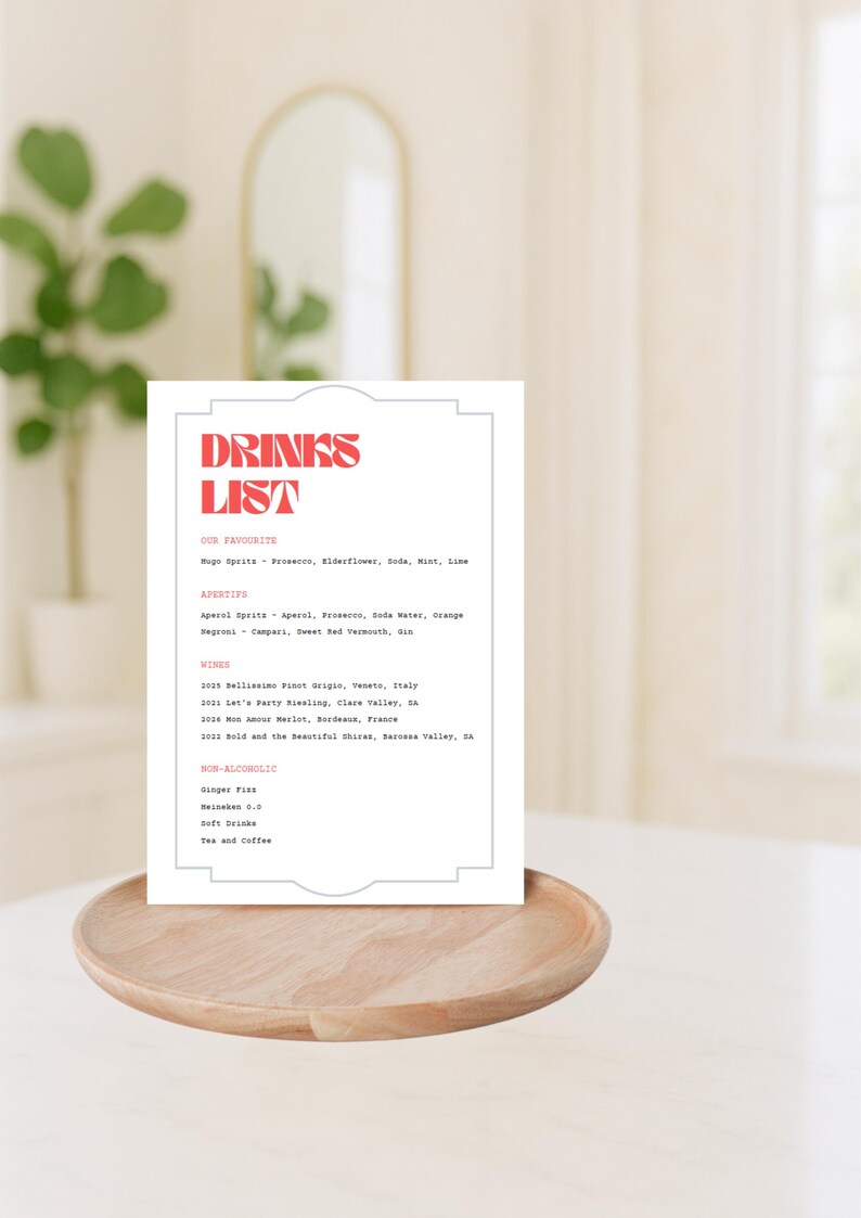 Puede incluir: Una tarjeta blanca con una lista de bebidas impresa en rojo y gris. La lista incluye nuestras bebidas favoritas, aperitivos, vinos y opciones sin alcohol.