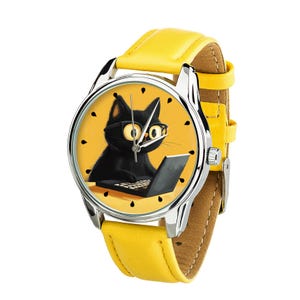 Könnte beinhalten: Eine gelbe Lederarmbanduhr mit einem silbernen Gehäuse, auf dem eine schwarze Katze mit Brille zu sehen ist, die einen Laptop benutzt. Das Zifferblatt der Uhr hat einen gelben Hintergrund mit schwarzen Markierungen.