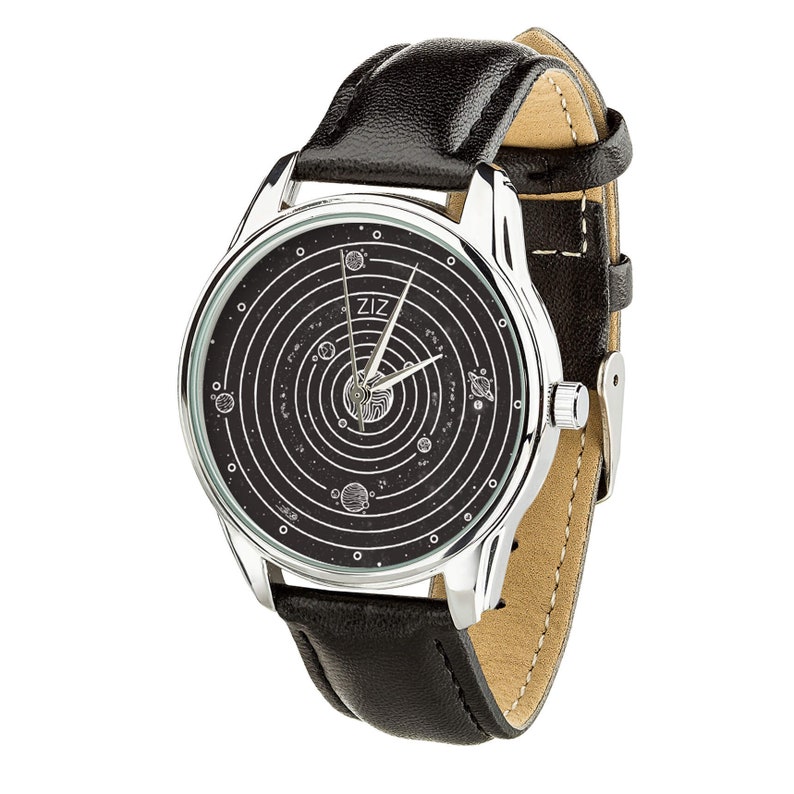 Pu&ograve; includere: Un orologio argentato con cinturino in pelle nera e quadrante nero con un design a sistema solare. Il quadrante dell'orologio ha la scritta "ZIZ" stampata.