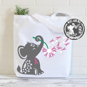 May include: A grey elephant with pink polka dots blows pink ribbon-shaped dandelion seeds. The elephant is holding a green stem in its trunk. The text "MABS AND WAL SVG PNG DXF" is in a circle with a floral design.