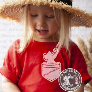 May include: A red t-shirt with a white pocket featuring a pink elephant design. The pocket has the text "Copyright MabsAndWal" inside. A separate image shows a white elephant design with the text "SVG PNG DXF" in a circle.