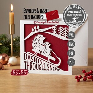 May include: A white paper Christmas card with a red interior features a cut-out design of two hedgehogs sledding. The card reads "Dashing Through the Snow" and measures 5.5 x 5.5 inches. Includes envelope and insert files.