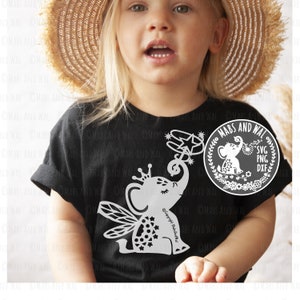 May include: A black t-shirt featuring a white graphic of a fairy elephant holding a star. The graphic includes the text "Copyright Mabanda". The shirt is being worn by a child wearing a straw hat. A white circle with the text "MABS AND WAL SVG PNG DXF" is in the top right corner of the image.