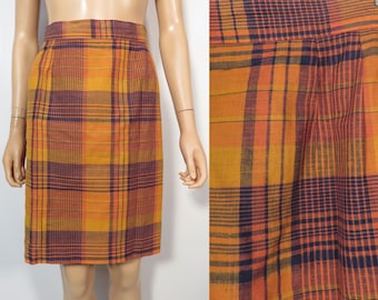 May include: A plaid skirt in orange, brown, and black. The skirt is knee-length and has a straight silhouette.