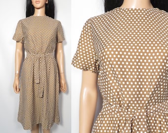 Puede incluir: Un vestido marrón con lunares blancos y un lazo en la cintura.