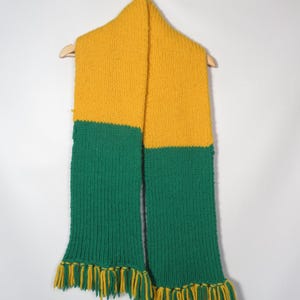 May include: A yellow and green knitted scarf with fringe on the ends.
