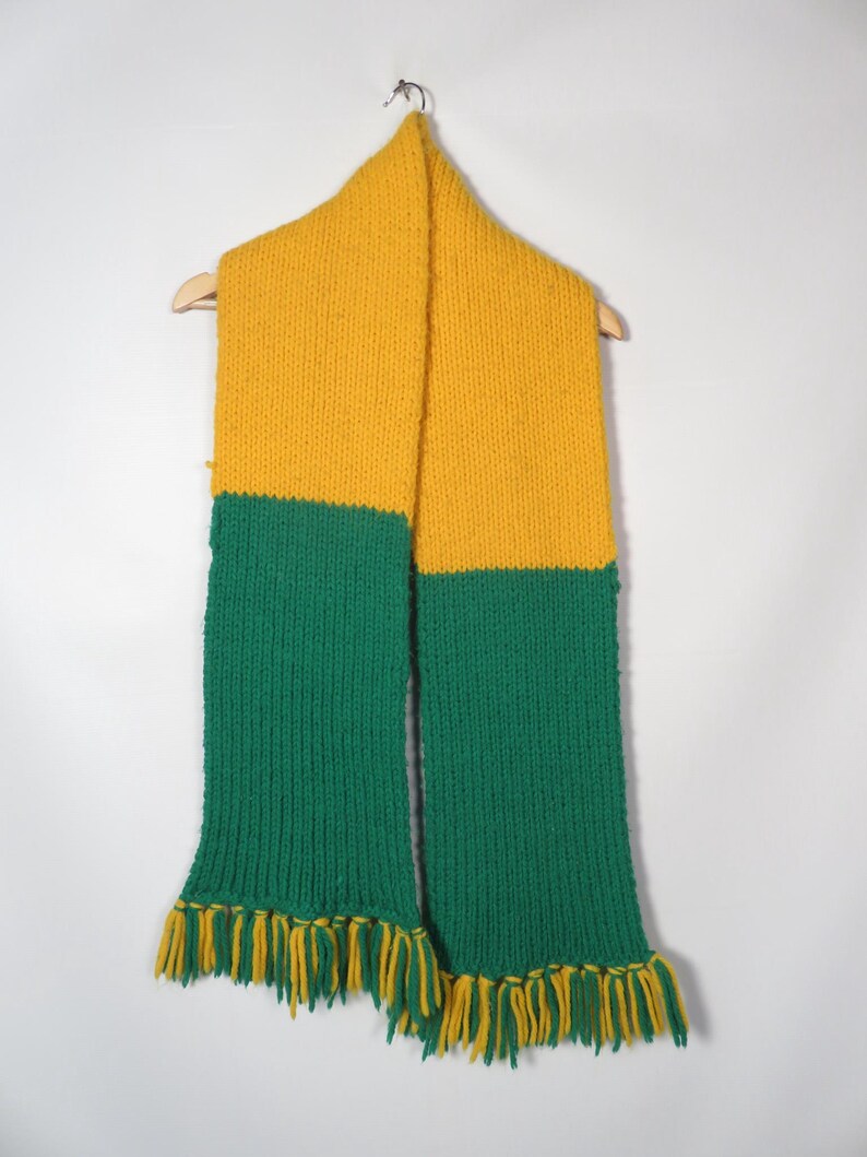 May include: A yellow and green knitted scarf with fringe on the ends.