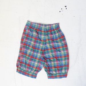 May include: Red, green, blue, and yellow plaid shorts with a wide elastic waistband.