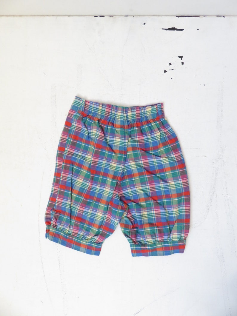 May include: Red, green, blue, and yellow plaid shorts with a wide elastic waistband.