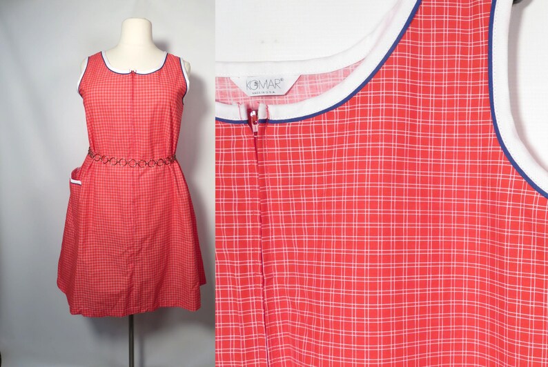 May include: A vintage red and white checkered dress with a white collar and trim. The dress has a zipper down the front and a decorative belt. The dress is sleeveless and has a knee-length hemline. The dress is displayed on a mannequin.