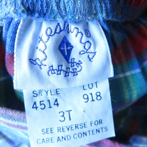 May include: White tag with blue text and a blue diamond logo. The tag reads "Style 4514 Lot 918 3T See Reverse for Care and Contents".
