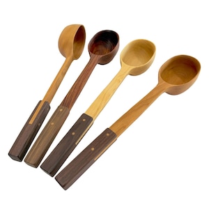 Può includere: Quattro mestoli in legno con coppe profonde e arrotondate e manici lunghi e dritti. Ogni mestolo presenta un design bicolore con una coppa in legno chiaro e una sezione del manico rettangolare più scura fissata con due piccoli rivetti metallici.