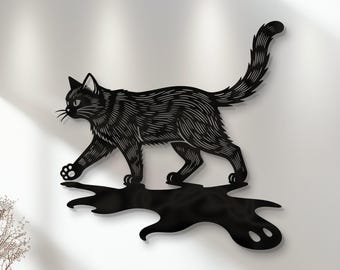 May include: Black metal cat wall art. The cat is depicted walking with its tail up. The cat's body has etched details. The cat's shadow is also visible. The art is mounted on a white wall.