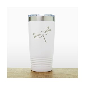 May include: White stainless steel tumbler with a laser-etched dragonfly design. The tumbler has a double-wall insulated design and a lid.