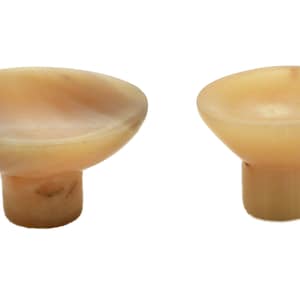 Op de afbeelding: Twee kleine, crèmekleurige hoornkommen met een voet.