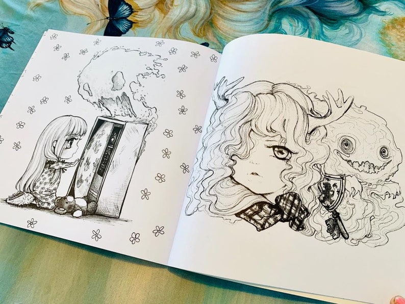 May include: A black and white colouring book page featuring two illustrations. The first illustration is of a young girl with long hair looking at a television with a skull-shaped cloud above it. The second illustration is of a girl with long hair and a creature with antlers and a toothy grin.