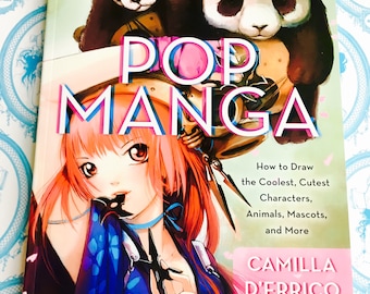 May include: A hardcover book titled "POP MANGA" featuring a colorful illustration of a manga character with pink hair and a panda. The book cover also includes the text "How to Draw the Coolest, Cutest Characters, Animals, Mascots, and More."