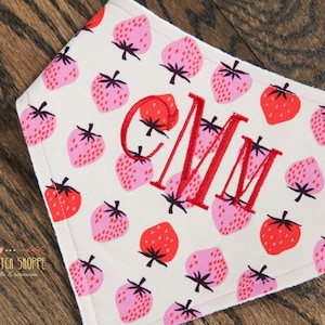 May include: A white bandana with a red and pink strawberry pattern. The bandana is personalized with the monogram "CMM" in red embroidery.