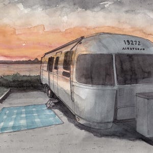May include: Watercolour painting of a silver Airstream trailer parked on a concrete pad with a blue and white checkered blanket. The sky is a blend of orange and grey, suggesting a sunset. The trailer has the number "19272" on its roof.
