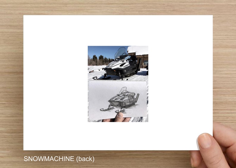 Op de afbeelding: Een zwart-witte schets van een sneeuwscooter op een vel papier. De sneeuwscooter is gedetailleerd getekend, met een voorruit, een stuur en rupsbanden. De schets wordt in een hand gehouden, en de achtergrond is een wazig beeld van een sneeuwscooter in de sneeuw.