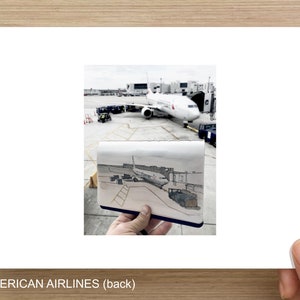 May include: An image of an American Airlines airplane at an airport gate. A small sketch of the same scene is held in front of the image. The text "AMERICAN AIRLINES (back)" is at the bottom of the image.