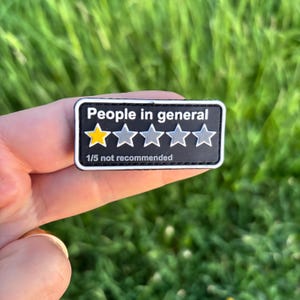 May include: A black rectangular patch with white text that reads "People in general" above a rating of one out of five stars. The first star is yellow, and the rest are gray. The text "1/5 not recommended" is below the stars.