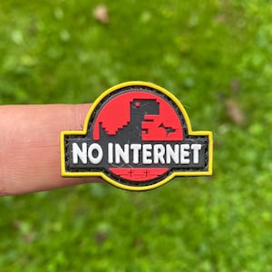 May include: A yellow, red, and black patch with a pixelated dinosaur and the text "NO INTERNET".
