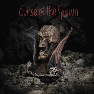 May include: A dark, detailed, sculpted bust of a demonic figure with a skull-like face and a cape. The figure is made of a dark, metallic material and has a chain around its neck. The bust is set against a dark, rocky background. The text "Curse of the Spawn" is written in red above the figure.
