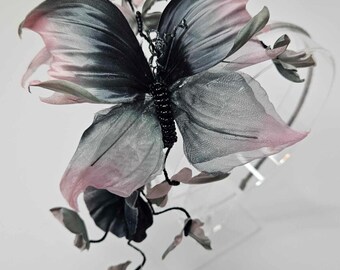 Può includere: Un cerchietto per capelli a forma di farfalla nero e rosa con un delicato design a filo e un corpo perlato. Il cerchietto è realizzato in un tessuto morbido e trasparente ed è perfetto per aggiungere un tocco di fantasia a qualsiasi outfit.