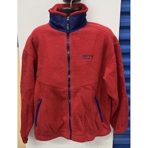 May include: Red fleece zip-up jacket with a blue and green collar and a navy blue zipper. The jacket has a logo on the front that says "EBTEK East Coast".