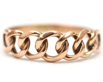 May include: A gold chain ring with a thick, linked design.