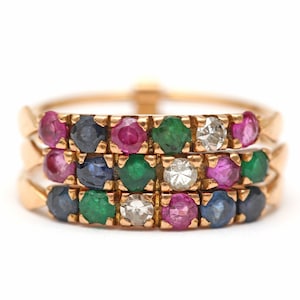 May include: A gold ring with three bands of gemstones. The bands are set with rubies, sapphires, emeralds, and diamonds.
