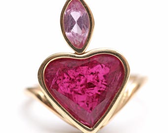 May include: A gold ring with a large heart-shaped ruby gemstone and a smaller pink marquise-shaped gemstone on top.