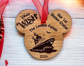 May include: A wooden Mickey Mouse-shaped ornament with the text "Disney Wish" and "The Landon Family" on it. The ornament also features a silhouette of a Disney cruise ship with the text "Our 1st Disney Cruise" and "2024" on it.
