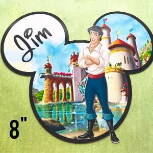 May include: A personalized 8-inch Mickey Mouse-shaped sticker featuring a cartoon image of Prince Eric from Disney's The Little Mermaid. The sticker has a white background with the name "Jim" written in black cursive. The image shows Prince Eric standing in front of his castle, with a blue sky and white clouds in the background.