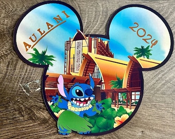 May include: A Mickey Mouse ear-shaped graphic featuring Stitch from Lilo & Stitch in front of a tropical resort scene. The graphic includes the text "Aulani 2024" in gold lettering. Stitch is wearing a lei and grass skirt.
