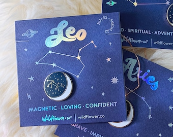 May include: Three blue cards with holographic lettering and constellation designs. Each card features a different zodiac sign: Leo, Sagittarius, and Aries. Each card has a white circle with a gold zodiac symbol inside.