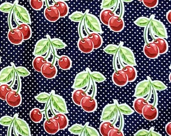 May include: A navy blue fabric with a white polka dot pattern and a repeating pattern of red cherries with green stems and leaves.