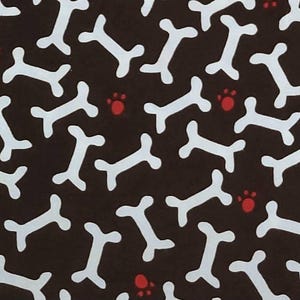 May include: A repeating pattern of white dog bones and red paw prints on a dark brown background. The design is evenly spaced and covers the entire surface, creating a playful and whimsical aesthetic.