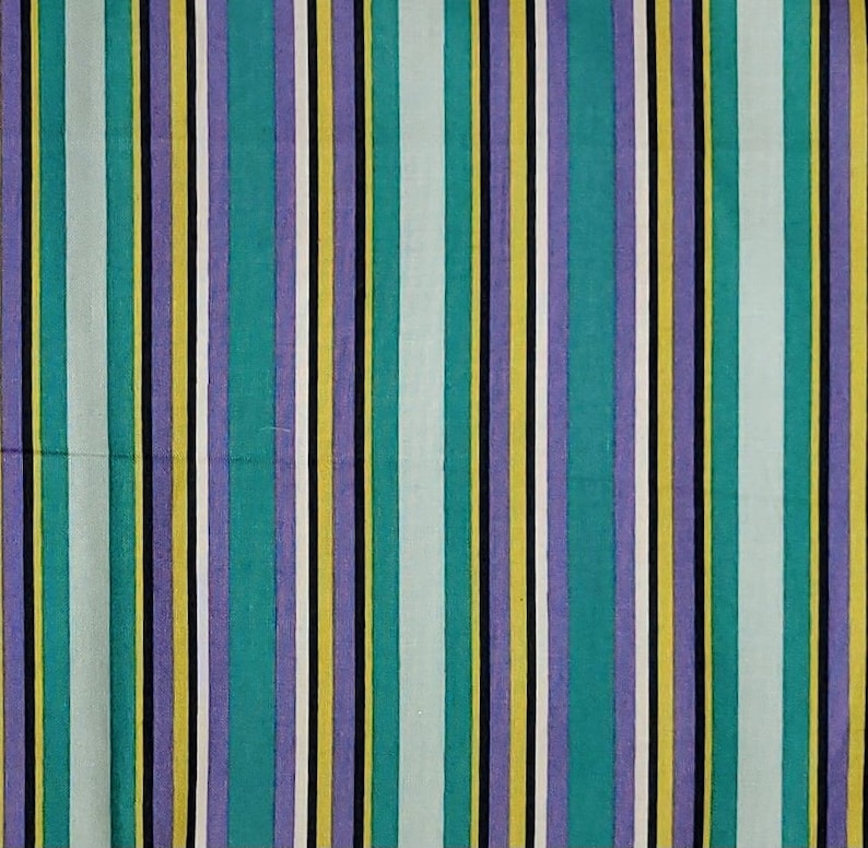 May include: A striped fabric with alternating bands of teal, purple, yellow, white, and black.