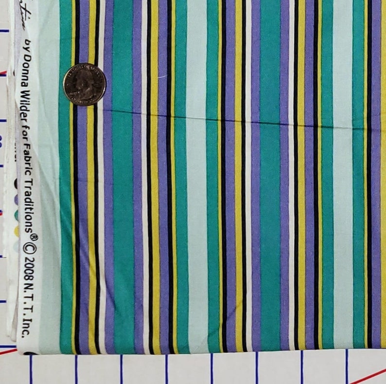 May include: Striped fabric with alternating stripes of yellow, teal, purple, black, and white. The fabric is labeled "Fabric Traditions&reg; &copy; 2008 N.T.T. Inc. by Donna Wilder for Fabric Traditions&reg;"